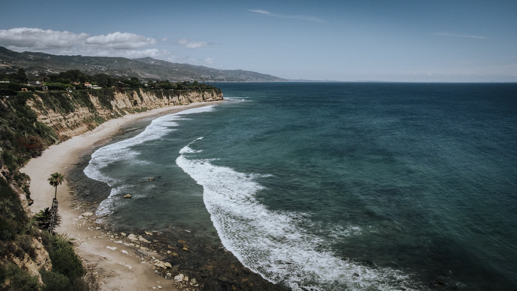 Surf breaking along the cliffs, seen from above