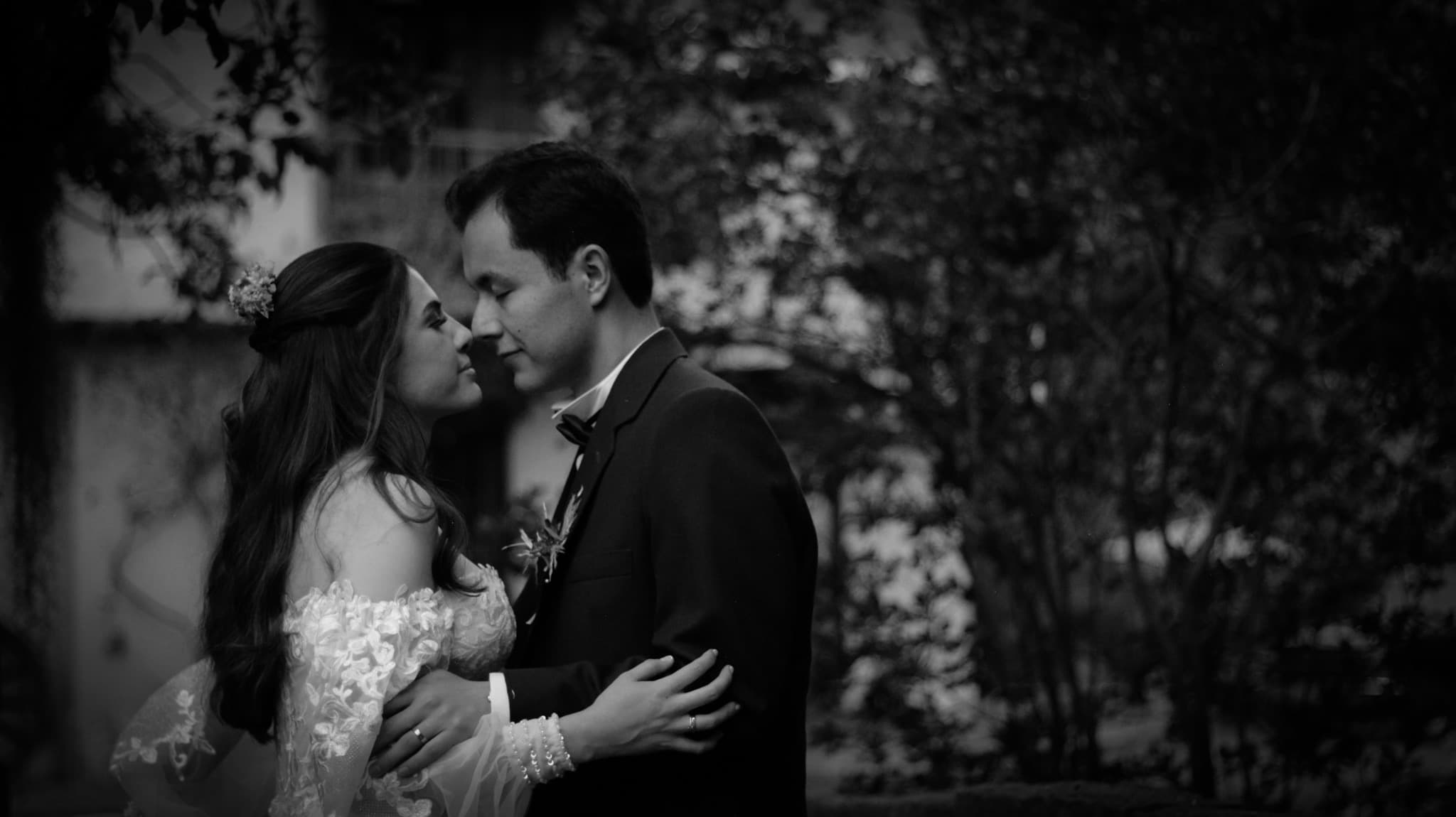 A bride and groom leaning close, a moment before the kiss